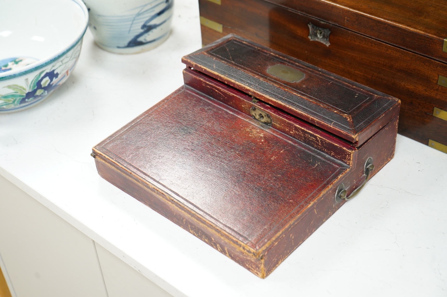 A Victorian brass bound mahogany writing slope and a Regency leather covered writing slope, 50cm wide